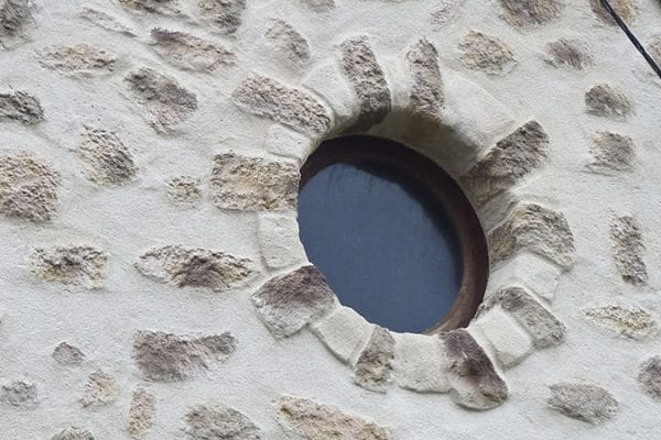 Façade en pierres vues et œil de bœuf